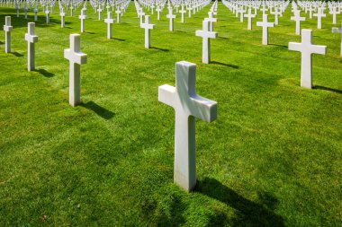 Fransa 'nın Normandiya kentindeki Amerikan askeri mezarlığında ölen askerleri onurlandıran beyaz haçlar. Huzurlu, saygılı ve ağırbaşlı bir atmosfer..