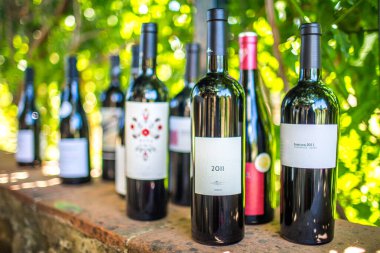 A variety of Spanish red wines arranged on a rustic wooden ledge. clipart