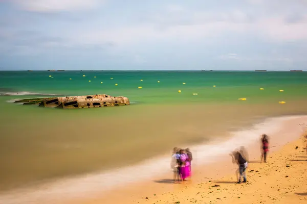 stock image Tourists taking pictures in fronit of the remains of a WW2 Mulberry harbour, Arromanches-les-Bains, Normandy, France