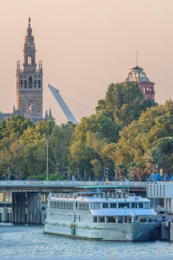 Guadalquivir Nehri 'ne yanaşan bir yolcu gemisi Alamillo Köprüsü ve Giralda arka planda, Seville, İspanya.