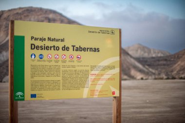 İspanya 'nın Almerya kentindeki Tabernas Çölü Doğal Parkı' nın girişinde arka planda dağlarla birlikte imza atın..