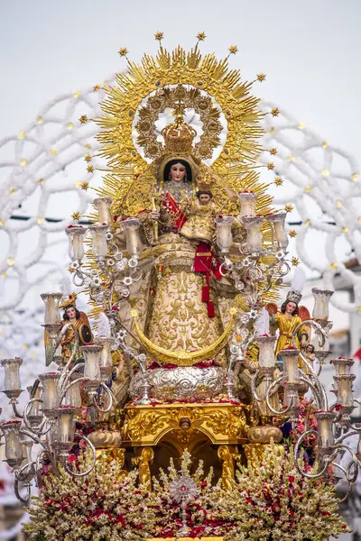 La Virgen del Rosario, 18. yüzyıldan kalma bir heykel, Carrion de los Cespedes, Sevilla, İspanya 'da bir geçit töreninde. İmaj zengin dini gelenekleri ve kültürel mirası tasvir ediyor..