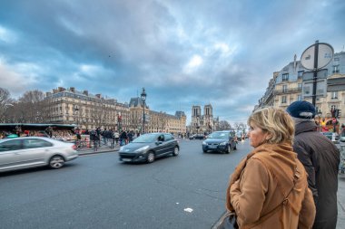 Paris, Fransa 'daki Quai Saint Michel Caddesi' nde Notre Dame ile sokakta duran bir çift..