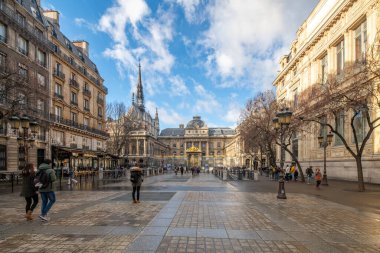 Güneş ışığı, Lutece Caddesi 'ni Saint Chapelle ve Palais de Justice manzarasıyla yıkıyor.