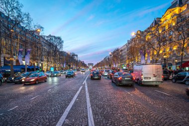 Şenlikli aydınlanma şafakta Şanzelize boyunca.