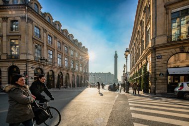 Yayalar geçtikçe güneş ışığı Rue de la Paix 'e vuruyor, Vendome Meydanı uzaklardan görülebiliyor..