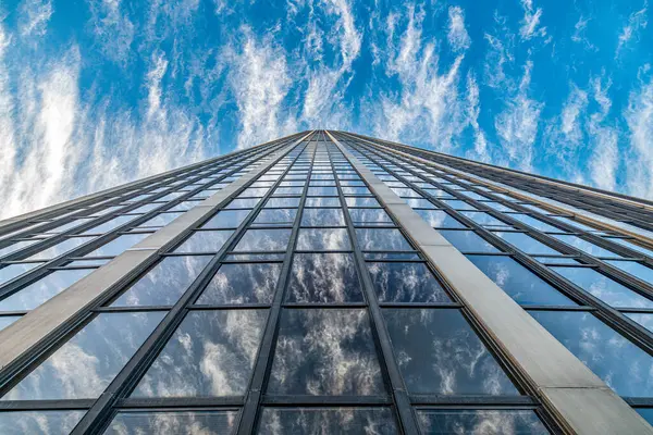 stock image Looking up at the towering Montparnasse Tower against a backdrop of wispy clouds.