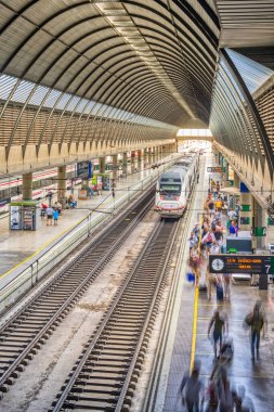 İspanya, Seville 'deki Santa Justa İstasyonu' nda orta mesafeli bir trenden inen yolcular. Meşgul şehir taşıma sahnesi.