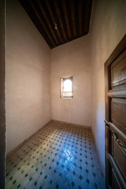 Geleneksel döşemeleri ve Cherratine Madrasa 'da küçük pencereleri olan seyrek bir öğrenci odası. Fez, Fas.