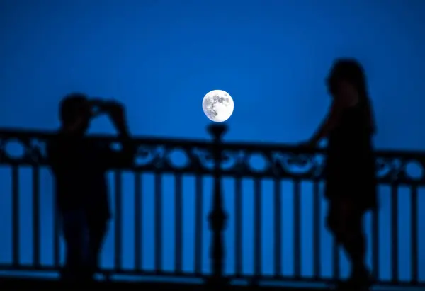 stock image Couple taking pictures under moonling on the Triana bridge, Seville, Spain.