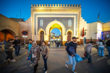 Bir grup insan, Fas, Fez Medine 'sindeki Mavi Kapı olarak da bilinen tarihi Bab Boujloud' un önünde yürüyor..