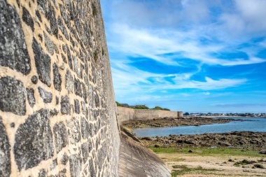 Lorient, Brittany, Fransa 'daki Port Louis Citadelle' in çarpıcı manzarası, tarihi mimariyi kıyı zeminiyle sergiliyor..