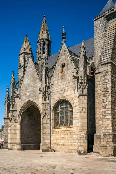 stock image View of the historic Collegiale Saint Aubin in Guerande, France, showcasing its beautiful stone architecture and intricate details against a clear blue sky.