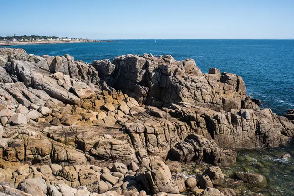 stock image Stunning view of the rocky coastline of Ouistreham in Brittany, France. Clear blue ocean water under a sunny sky.