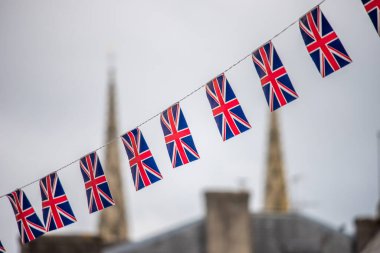 Arka planda Quimper, Brittany, Fransa 'nın bulanık manzaralı bir dizide Union Jack bayrakları sergilendi.