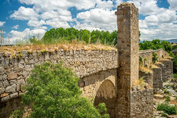 stock image Historic medieval bridge spanning the Tormes river in Puente del Congosto, a charming town in Salamanca, Spain.