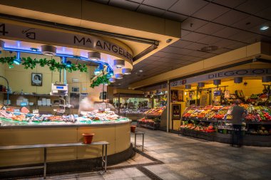 İspanya, Sevilla 'da canlı ve hareketli Mercado de la Encarnacion' u gösteren uzun pozlu fotoğraf. Piyasa taze ürünler ve deniz ürünleri tezgahıyla dolu..