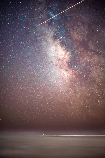 Stock image Starry night sky featuring the Milky Way over the calm Atlantic Ocean at Isla Canela Beach, Ayamonte, Spain.