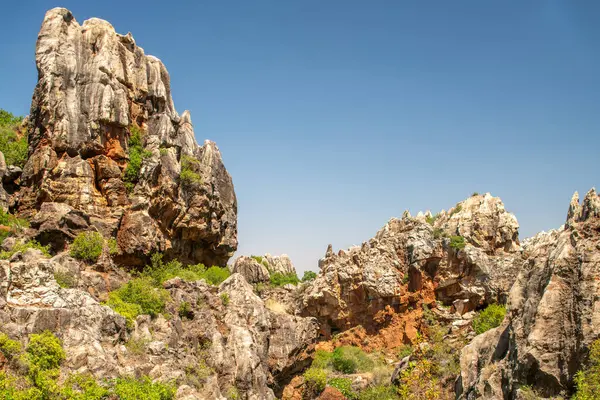 İspanya 'nın Sierra Norte de Sevilla kentindeki Cerro del Hierro Doğal Anıtı' nda engebeli kaya kayalıkları ve açık mavi gökyüzü bulunan görkemli karst oluşumları..