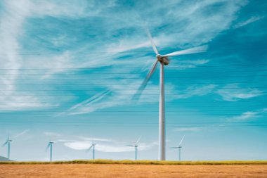 Rüzgar türbinleri, İspanya 'nın Tarifa şehrinde berrak mavi gökyüzü ile yenilenebilir enerji üretiyor. Görüntü, sürdürülebilir enerji kavramını yakalar.