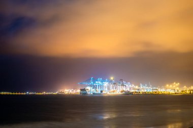 El Rinconcillo plajı, arka planda aydınlatılmış Algeciras limanının güzel bir manzarası olan İspanya..