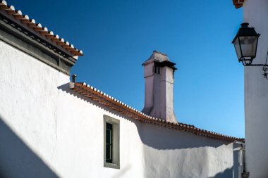 Serene view of traditional white-washed houses and tiled roofs in Fuenteheridos, province of Huelva, Andalucia, Spain on a sunny day. clipart