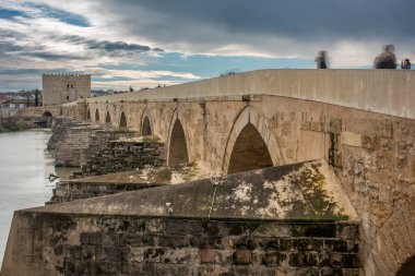 View of the historic Roman Bridge and Calahorra Tower in Cordoba, Andalusia, Spain. Spectacular ancient architecture with people walking. clipart