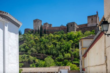 Güneşli bir günde Granada, Endülüs, İspanya 'nın büyüleyici tarihi Albaycin bölgesinden La Alhambra kalesinin çarpıcı manzarası.