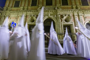 Cofradia del Resucitado 'dan Nazarenos San Luis de los Franceses, Sevilla' nın barok cephesinin önünde Semana Santa Santa.