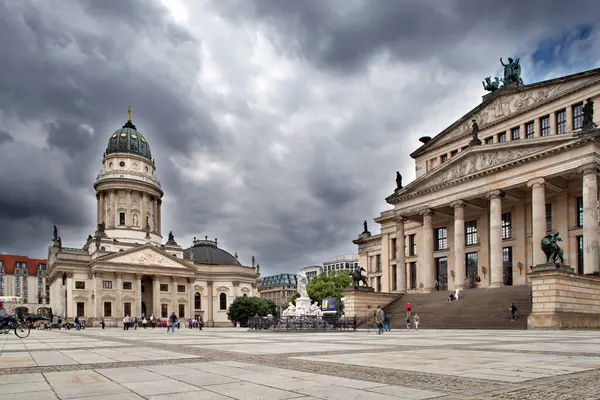 stock image Explore the stunning architecture of Deutsche Dom and Konzerthaus in Gendarmenmarkt, Berlin, as clouds loom overhead.