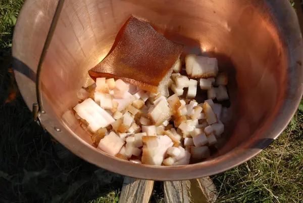 stock image Diced pork lard (bacon) in a copper caulrdon ready to cook. Basis of a traditional Hungarian outdoor dish goulash (gulyas) or fish soup or stew (porkolt).