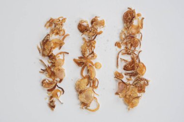 Kızarmış Endonezya Kızartması (Bawang Goreng) veya beyaz arka planda izole edilmiş yuvarlak şekilli arpacık soğanı yığını.