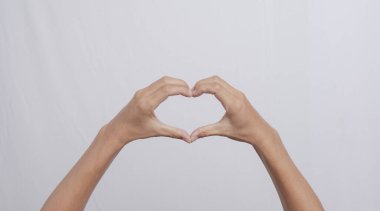 Güzel insan eli kalp işareti veriyor. El hareketi, izole edilmiş beyaz bir arkaplanda kalp işareti oluşturuyor. Fotokopi alanı olan güzel kadın elleri. Mutluluk gününde aşk kavramı.