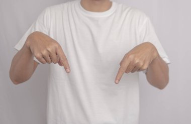 Beyaz gömlekli genç bir Asyalı parlak beyaz arka planda duruyor ve iki eliyle aşağıya bakıyor. Bu resim promosyon içeriği için ideal.