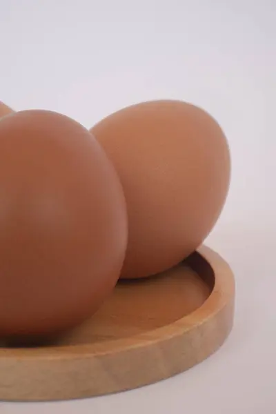 Beyaz arka planda izole edilmiş kahverengi yumurtalar. Yumurta pişirmede yaygın bir malzemedir. Yumurta proteini etkili bir şekilde emilir. Yemek konsepti. Modern tavuk çiftçiliği.