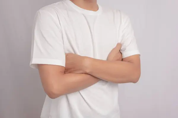 Kolları katlanmış, boş tişörtlü adama yaklaş. Bir erkekte boşluklar..