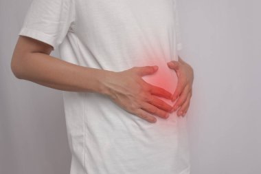 Adamın mide ağrısı ve mide iltihabı vardı. Elini karnına koydu ve rahatlamak için sıktı. Rahatlaması için tuvalete gitmesi gerekiyor. Kaka yapması lazım..