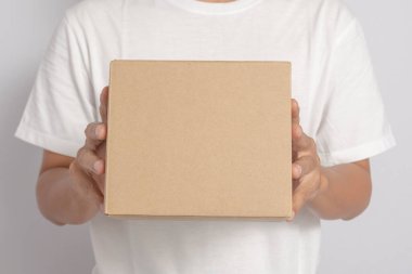 Mutlu bir adam beyaz arka plandaki bir müşteriye karton ya da kargo paketi taşır..