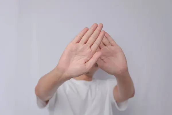 Farkındalık ya da çatışma için beyaz arka planda mağdur ile istismar, el ve dur. Aile içi şiddet, korunma veya nefsi müdafaa için el hareketi. Rüşvet biçimlerinin reddedilmesi.