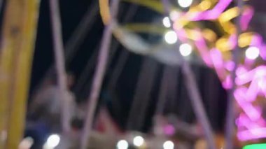 Eğlence parkında dönen, aydınlatılmış, odağını kaybetmiş, altın rengi bir atlıkarınca. Bulanık parlak atlı karınca geceleri parlıyor ve dönüyor. Çocukluğun parlak dönen sembolü. Eğlence fuarı atmosferi.