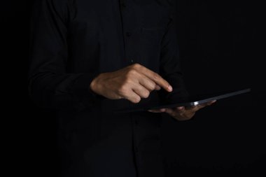 Akıllı telefonu işaret eden Asyalı işadamı, hisse senedi hareketlerini izlemek ve takıma hedefler hakkında bilgi vermek için tablet ekranı. İzole edilmiş bir adam tableti göstererek ona işaret ediyor..