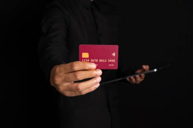 Siyah arka planda el ele tutuşan kredi kartı. Çevrimiçi yeni aktarımı kavra.