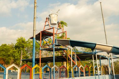 Neşeli bir aile, mavi gökyüzünün altındaki yeşil eğlence parkının tadını çıkarıyor..