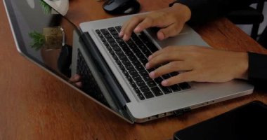 İşadamı profesyonel kullanıcının dizüstü bilgisayarda klavye kullanarak yavaş erkek elleri ev ofisinin masasında oturup bilgisayar yazılım uygulamaları teknoloji kavramı ile çalışır.,
