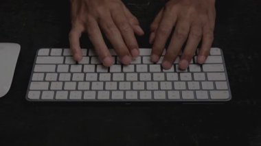 Bir adamın ellerinin yakın plan görüntüsü kişisel bilgisayar klavyesinin klavyesine tıklıyor. İnternet 'te bilgi arıyorum. Bir gazete için makale basmak. Bilgisayar korsanları sunuculara saldırıyor. siber suçlar.