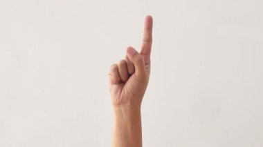 Beyaz arka planda birden beşe kadar sayan kadın elleri. Yetişkin bir Asyalı kadının eli beyaz arka planda birden beşe kadar sayıları gösteriyor. 4K yavaş çekim görüntüleri.