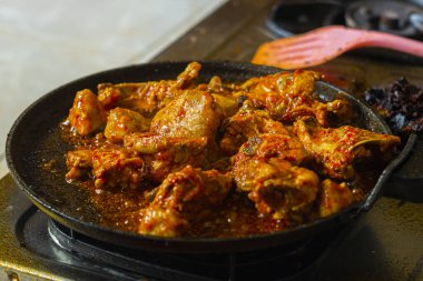 Gaz ocağında ızgara tavada ızgara kırmızı baharatlı tavuk. Sarı zerdeçal baharatlı çiğ tavuk eti, sarımsak ve ızgarada yeşillik pişiriyorum. Kızarmış tavuk dilimi..