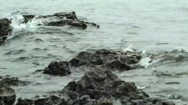 Dalgalar kıyıdaki kayalara çarpıyor. Deniz dalgaları kayalara çarpıyor. 4k.