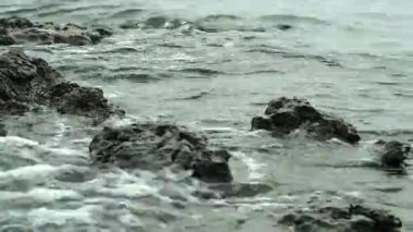 Dalgalar kıyıdaki kayalara çarpıyor. Deniz dalgaları kayalara çarpıyor. 4k.