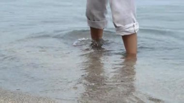 Genç bayanın ayakları gün içinde plajda oyun oynuyor..